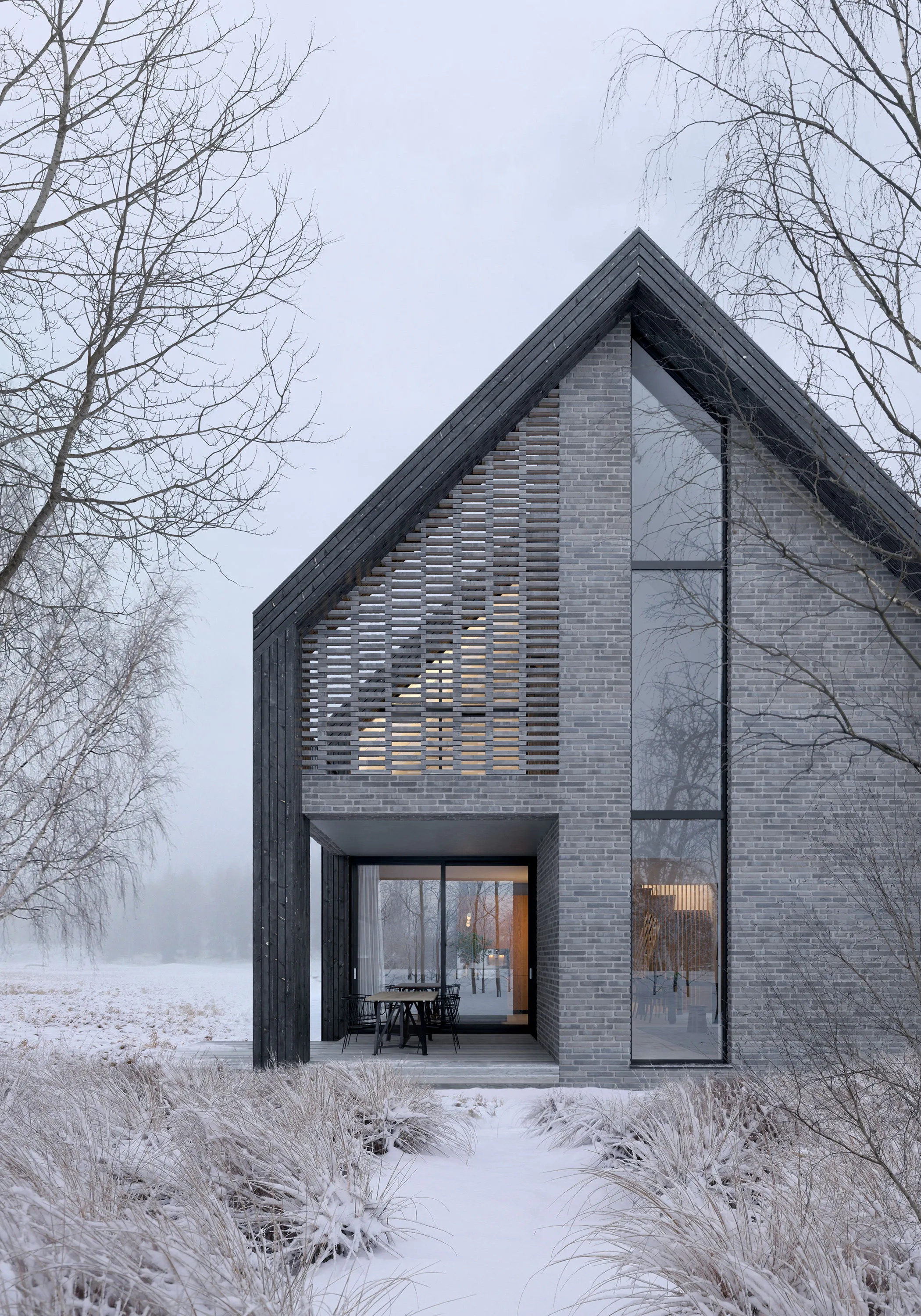 Dark gabled house standing in a snowy winter landscape.